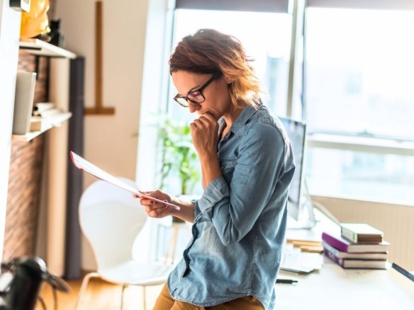 Mujer revisando la nota simple de una propiedad con datos registrales importantes